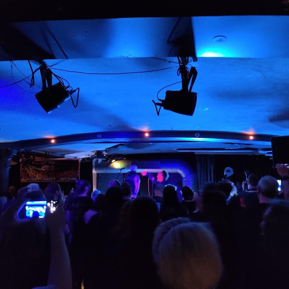 A concert venue with people watching a band.